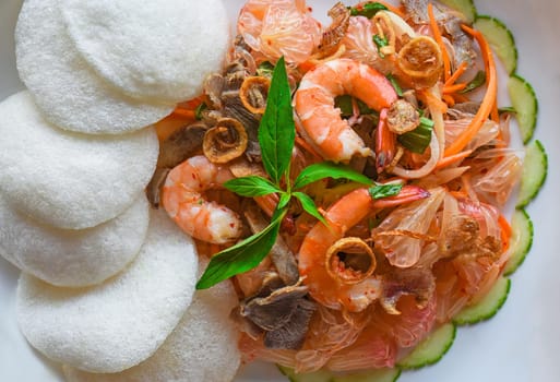 Salad made of shrimps and grapefruit isolated on black background top view