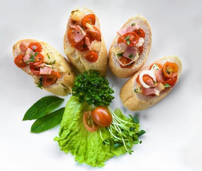 Bruschetta with tomatoes, ham,onion and olive oil on white plate close up