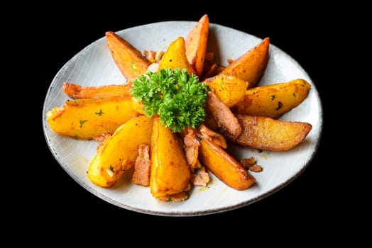 rustic potato wedges with bacon on black background top view