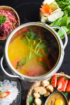 Korean spicy hot pot with beef meat and noodles on black background
