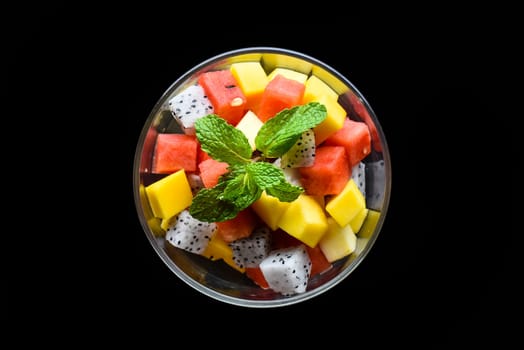 Fruit salad made of east asian fruits isolated on black background side view
