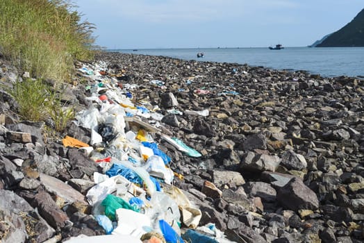 Terrible view of dirty beach in Khanh Hoa province with much trash on stones