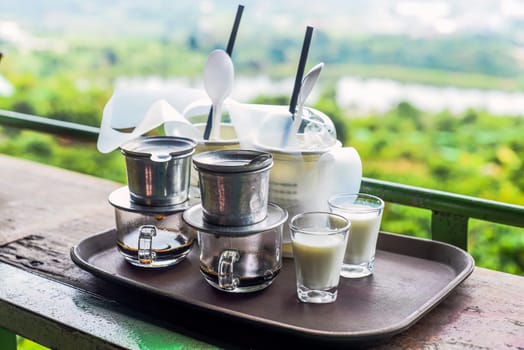 Vietnamese traditional coffee with milk on wooden table
