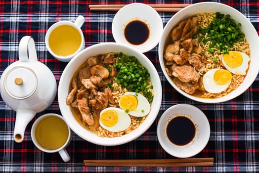 Japanese ramen with chicken and soy sauce on the table with teapot and green tea