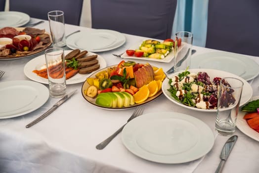 festive table set with Caesar salads, beets, fruit plate without people