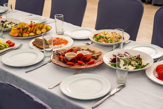 festive table set with Caesar salads, beets, fruit plate without people