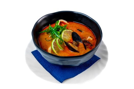Soup tom yum with seashells and mussels side view on white background