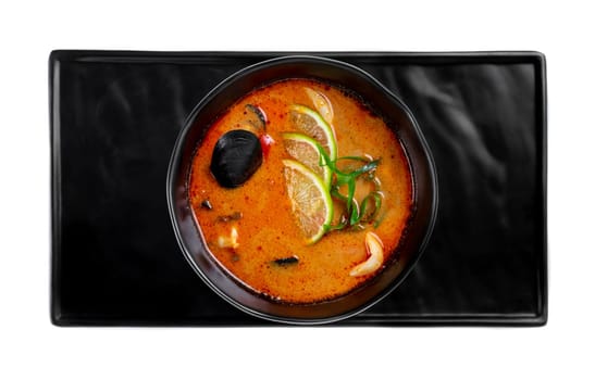 Soup tom yum with seashells and mussels top view on white background