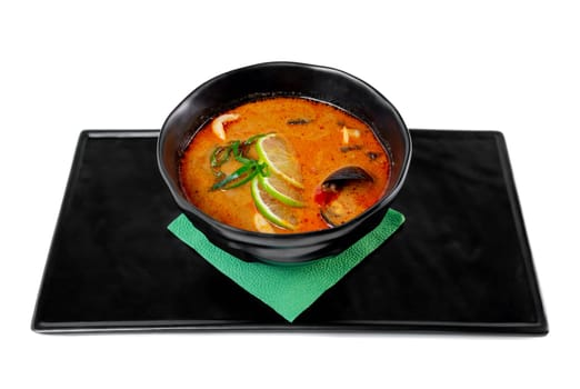 Soup tom yum with seashells and mussels top view on white background