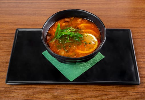Russian soup Solyanka on wooden table side view