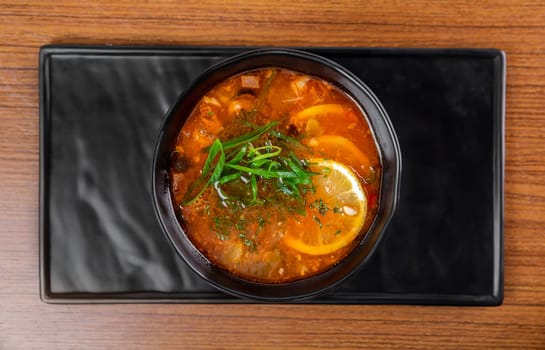 Russian soup Solyanka on wooden table side view