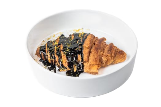 Sweet croissant with chocolate syrup in white plate on white background