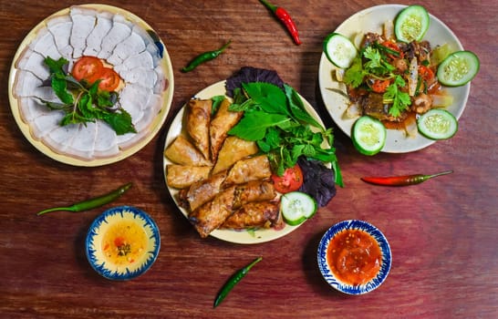 Traditional fried vietnamese spring rolls with pork, rice paper with sauces, meat slices and beef stew