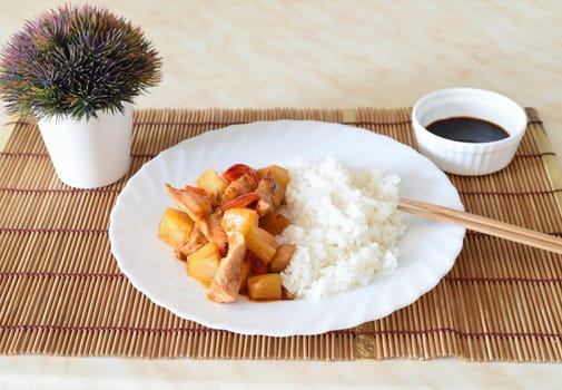 Chicken in sweet and sour sauce with pineapple, paprika and rice. asian cuisine