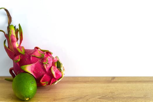 Pitaya or dragon fruit with lime on wooden table