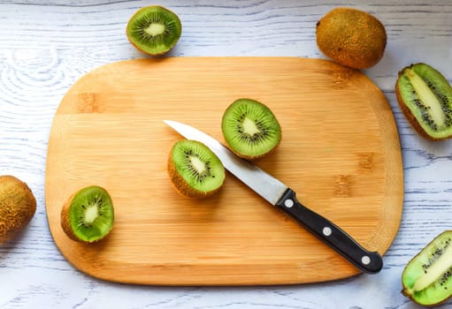 Sliced kiwi on cutting board with knife
