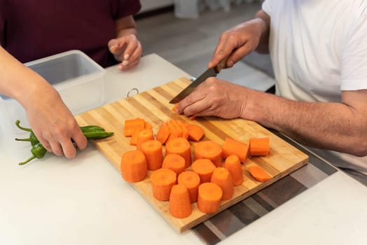 Man and woman cooking together, cutting vegetables for vegetarian diner