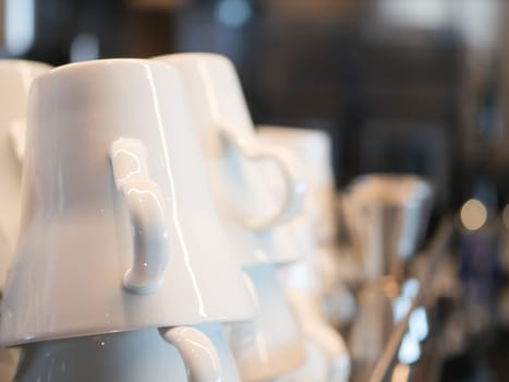 Neatly stacked white cups add a cozy vibe.