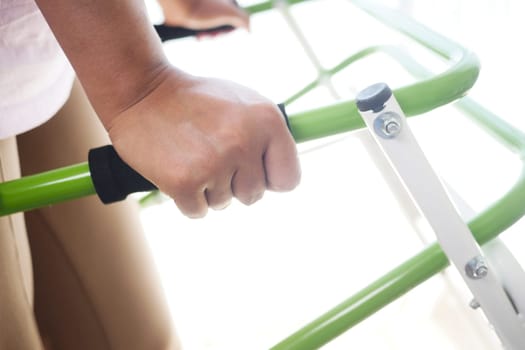 A hand grips a green equipment handle firmly.