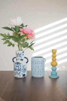 Colorful vases hold flowers on a well-lit table.