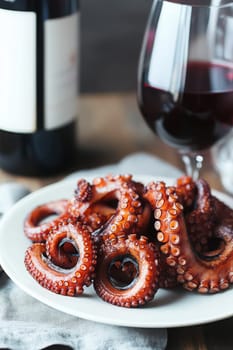 Fried octopus on a plate and a glass of wine. selective focus. Generative AI, food