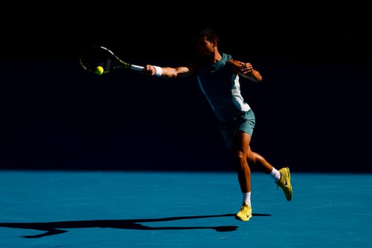 MELBOURNE, AUSTRALIA - JANUARY 19: Carlos Alcaraz of Spain hits a forehand to Jack Draper of Great Britain on day eight of the 2025 Australian Open at Melbourne Park on January 19, 2025 in Melbourne, Australia.