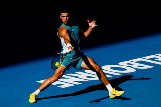 MELBOURNE, AUSTRALIA - JANUARY 19: Carlos Alcaraz of Spain hits a forehand to Jack Draper of Great Britain on day eight of the 2025 Australian Open at Melbourne Park on January 19, 2025 in Melbourne, Australia.