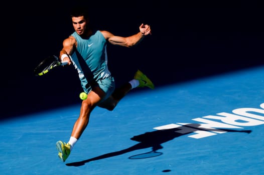 MELBOURNE, AUSTRALIA - JANUARY 19: Carlos Alcaraz of Spain hits a forehand to Jack Draper of Great Britain on day eight of the 2025 Australian Open at Melbourne Park on January 19, 2025 in Melbourne, Australia.