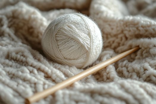 Ball of white thread and knitting needles lie on light yarn. Concept of knitting and home comfort.