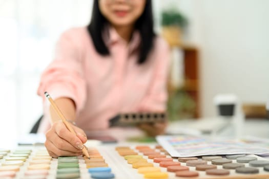 Interior designer choosing color swatches for a project at desk.