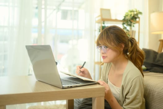 Focused female student working on an online course at home.