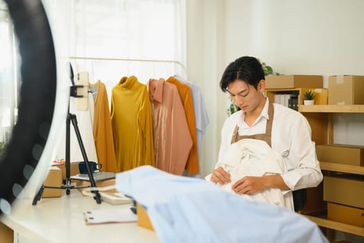 Online fashion retailer preparing clothing for online sales at home.
