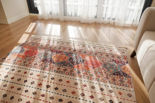 A colorful area rug lies on hardwood floors, adding warmth to the room.