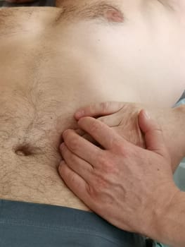 A real osteopath work with a man's abdomen. . Visceral massage to remove clamps and tension from the sphincters in the gastrointestinal tract. Visceral osteopathy