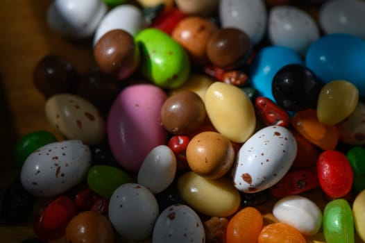 A vibrant mix of candy beans rests in natural light, showcasing a delightful rainbow of colors and shapes.