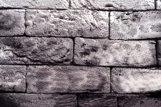 Monochrome old uneven wall lined with blocks