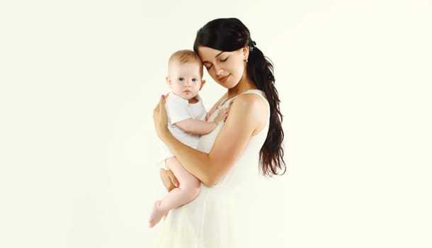 Portrait of happy young mother holding baby on white studio background