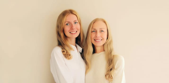 Portrait of happy smiling caucasian middle aged mother or sister and adult daughter together