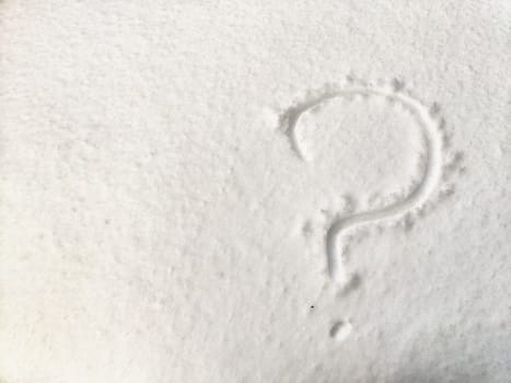 A question mark carved into a snow-covered surface raises doubts related to business matters in winter.