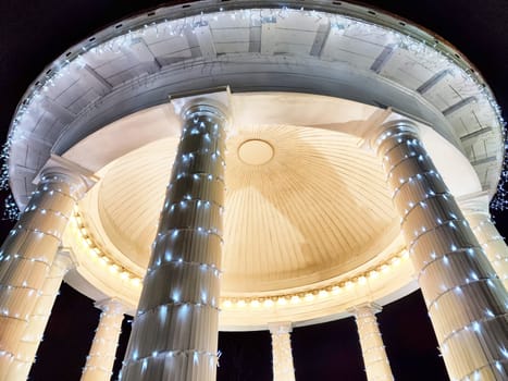 The gazebo is adorned with sparkling lights, creating a magical atmosphere in the park at night, inviting visitors to enjoy the enchanting ambiance.