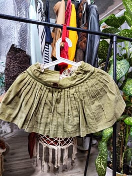 A variety of second-hand clothing items displayed for sale at a private garage sale, emphasizing eco-friendly choices.