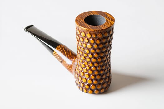 A beautifully crafted smoking pipe showcases its detailed texture and elegant shape.