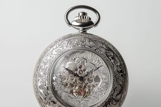 An ornate silver pocket watch showcasing intricate mechanics and beautiful designs.