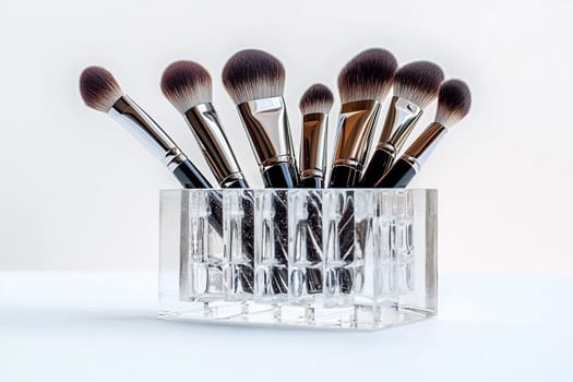 Various makeup brushes are displayed in a glass holder, ready for use in beauty applications.