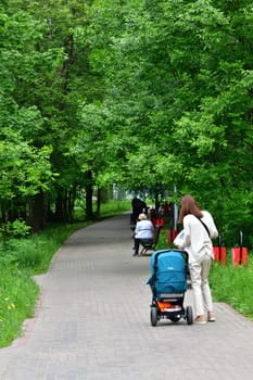 Moscow, Russia - 31 May. 2021. women walks with newborn in stroller in a park in Zelenograd