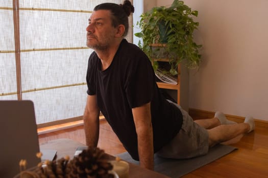 Man in sports suit doing yoga and meditating .Concept of yoga and meditation. Space for text.Exercise and meditation at home