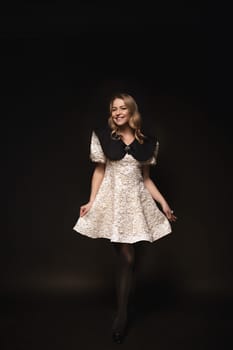 Beautiful blonde in a dress, portrait on a black background.