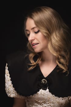 Beautiful blonde in a dress, portrait on a black background.