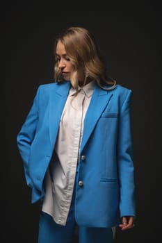 Beautiful girl fashion model poses in an elegant blue pantsuit. Fashion and beauty.