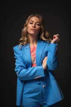Beautiful girl fashion model poses in an elegant blue pantsuit. Fashion and beauty.
